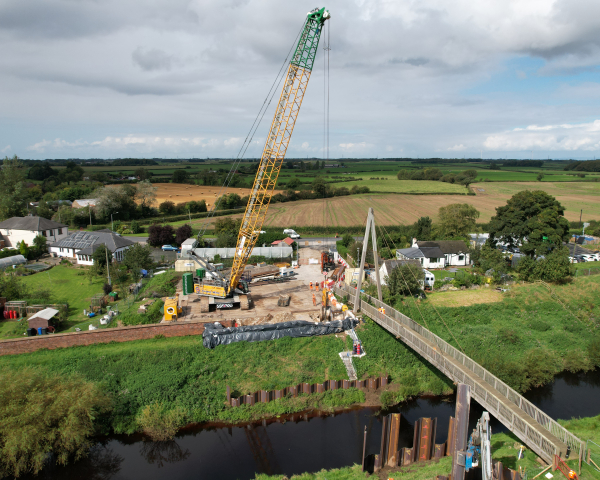 Drone shot of crane lifting piles into place 