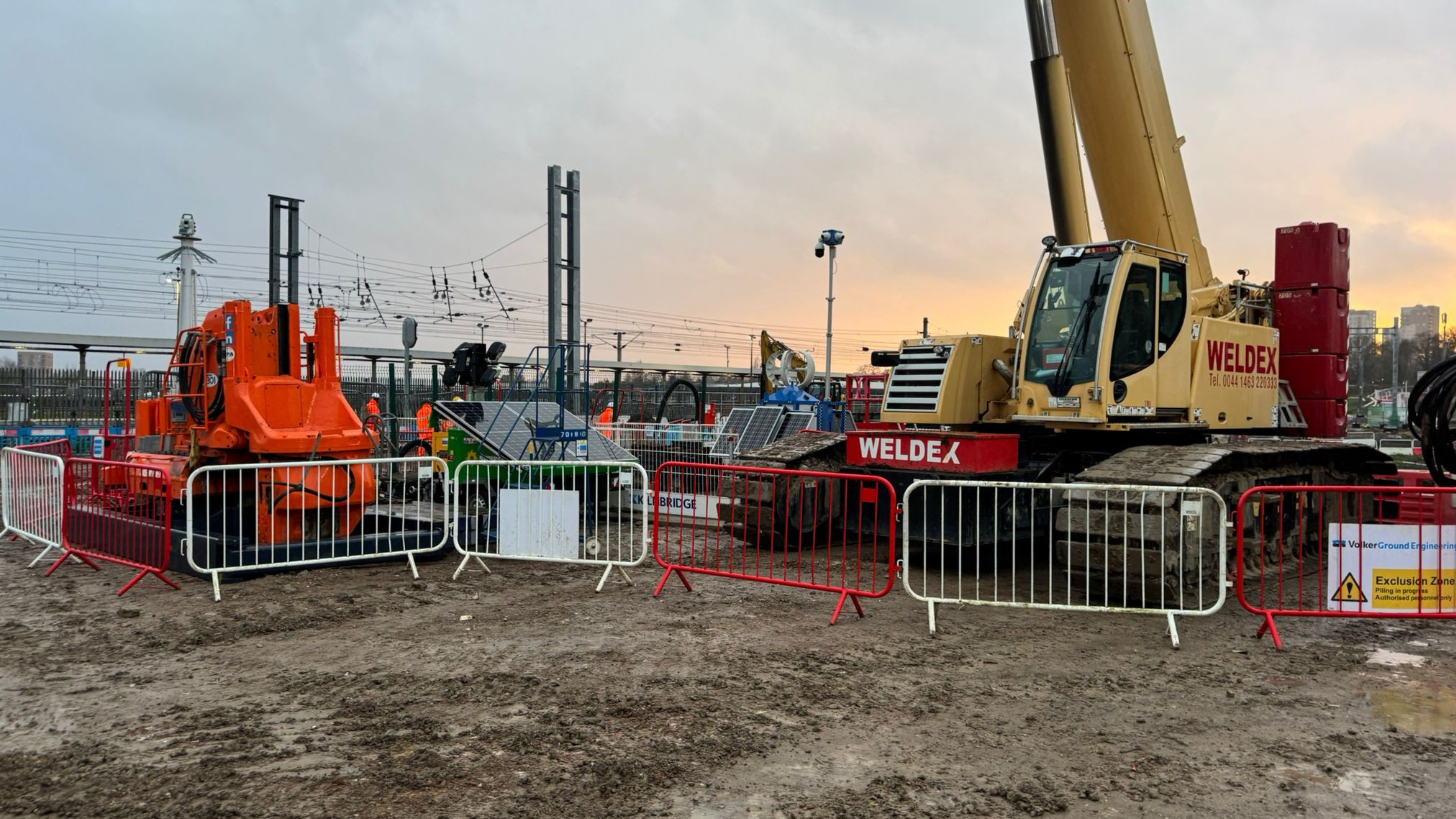 Piling rig by railway at dusk
